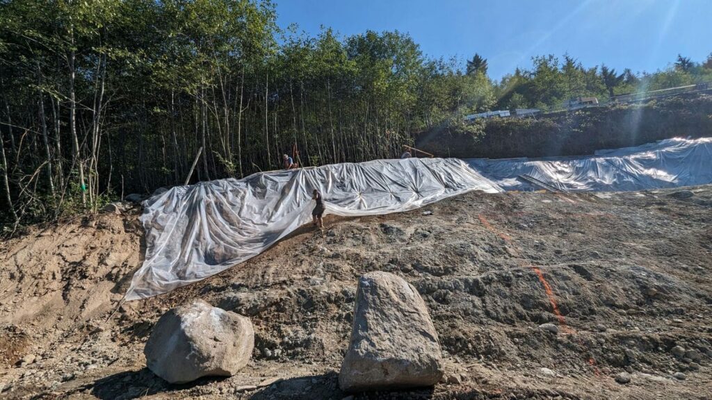 workers preparing sloped lot for construction