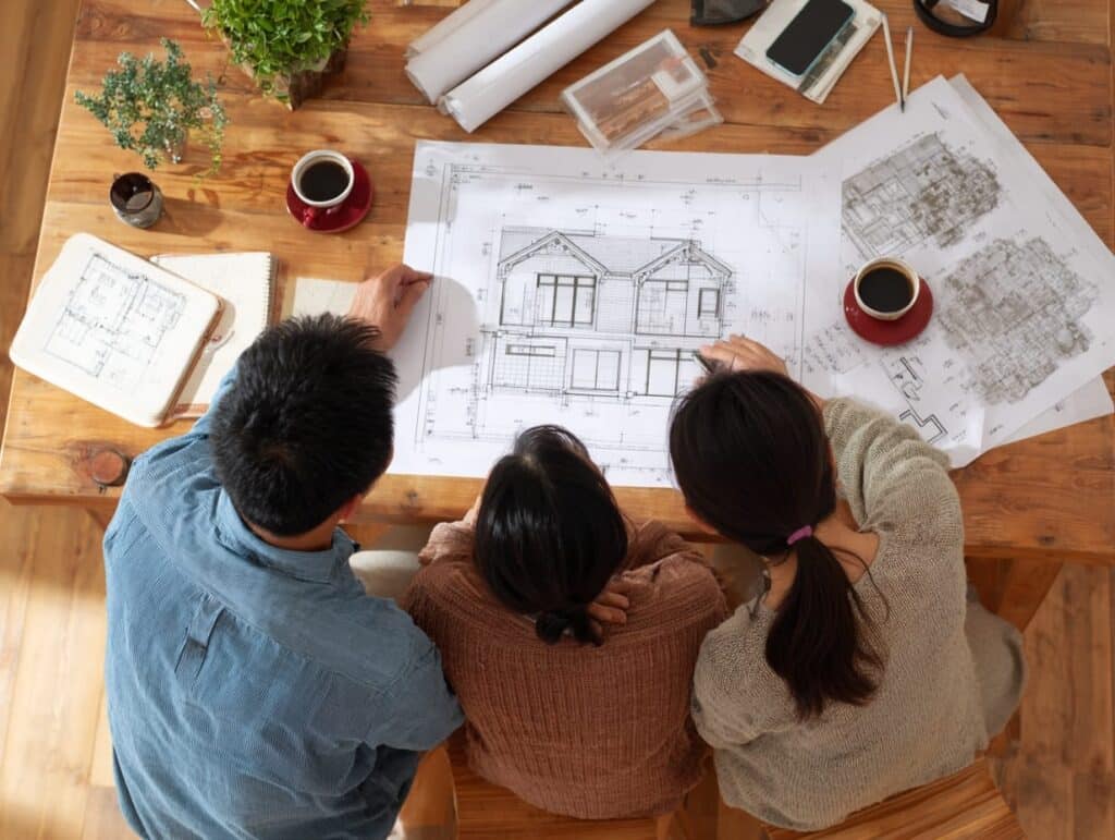 Homeowners reviewing custom home plans and financing options at a table