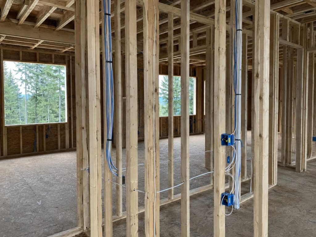 Open framing in a Greater Vancouver custom home with low voltage security wiring pulled through the studs before drywall