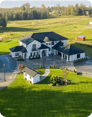 Aerial view of a modern farmhouse style custom estate home on acreage